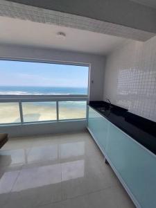 ein leeres Zimmer mit einem großen Fenster mit Meerblick in der Unterkunft Apartamento Frente Mar 2 dormitórios in Solemar