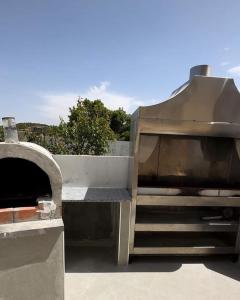 a barbecue grill with a pizza oven in at Mountain farm in Ajloun