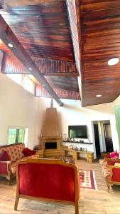a living room with wooden ceilings and a red couch at Mountain farm in Ajloun