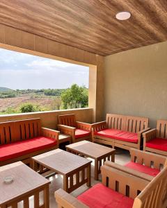 a restaurant with wooden chairs and tables and a large window at Mountain farm in Ajloun