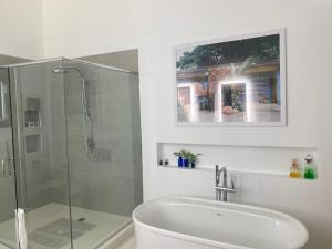a bathroom with a glass shower and a sink at Geejam in Port Antonio