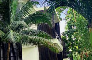 a black fence with palm trees in front of a building at Geejam in Port Antonio