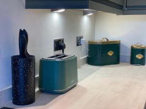 ein Zimmer mit drei grünen Mülltonnen in einem Zimmer in der Unterkunft Luxury Contractors Group Stay FAST Wifi FREE Parking in Bedford