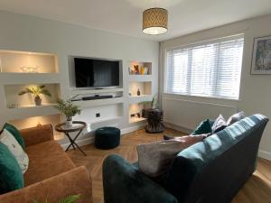 a living room with two couches and a flat screen tv at Luxury Contractors Group Stay FAST Wifi FREE Parking in Bedford