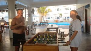 a man and a woman standing next to a table with a box at Loki del Mar in Máncora +154 photos