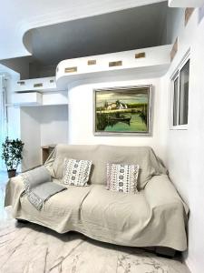 a couch in a living room with a painting on the wall at Apartamento Luminoso cerca de la PLAYA y PUERTO in Valencia