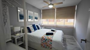 ラスパルマス・デ・グランカナリアにあるOHANAのベッドと天井扇風機のある寝室