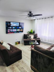 Poconos Retreat في بوشكيل: غرفة معيشة مع كنبتين وتلفزيون بشاشة مسطحة