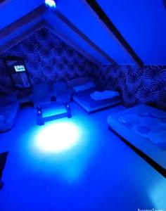 Habitación con luces azules en una habitación con sofás en Kuća za proslave i odmor ZMAJEVO GNEZDO, en Pe°ani