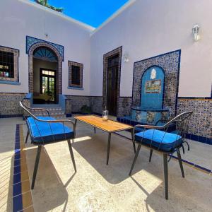 a patio with two tables and chairs in a room at Villa Octavia in Mérida