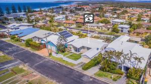 an aerial view of a city with houses and the ocean at Laze Daze in Yamba