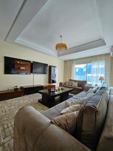 appartement familiale tanger R في طنجة: غرفة معيشة كبيرة مع أريكة وتلفزيون