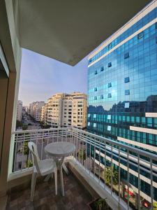 balcón con mesa, sillas y vistas a la ciudad en appartement familiale tanger R, en Tánger