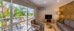 ein Wohnzimmer mit einem Sofa und einem Balkon in der Unterkunft Coral Coast Resort Accor Vacation Club Apartments in Palm Cove