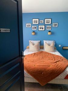 Thenay的住宿－Gîte La Cabuche proche du zoo de Beauval，蓝色卧室,配有带橙色棉被的床