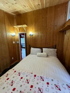 a bedroom with a bed in a wooden wall at Chalet Alpin Suisse Au Bord Du Lac in Morin Heights