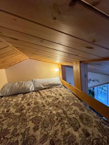 Cama grande en habitación con techo de madera en Chalet Alpin Suisse Au Bord Du Lac, en Morin-Heights