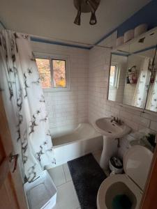 een badkamer met een bad, een wastafel en een toilet bij Chalet Alpin Suisse Au Bord Du Lac in Morin Heights