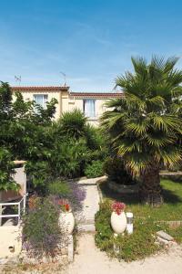 un jardin avec des fleurs et des plantes devant un bâtiment dans l'établissement Hôtel La Croix de Malte, à La Ciotat