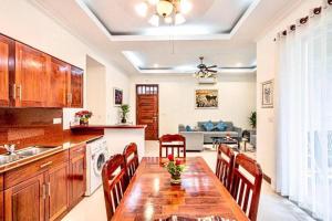 a kitchen and dining room with a wooden table and chairs at Elegant Escape Residence in Siem Reap
