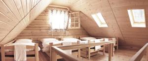 a room in a log cabin with beds and a window at Chata Wilka - całoroczny dom z bali na wyłączność z 3 sypialniami in Brzegi Dolne