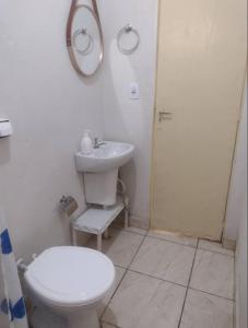 a white bathroom with a toilet and a sink at Casa em Uberaba com garagem in Uberaba