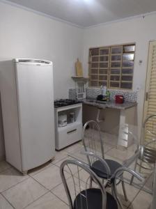 a kitchen with a refrigerator and a table and chairs at Casa em Uberaba com garagem in Uberaba