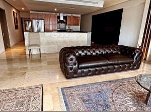 un sofá de cuero marrón en la sala de estar en Departamento de Lujo en Chipinque. La mejor vista., en Monterrey