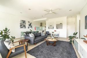 ein Wohnzimmer mit Sofa und Tisch in der Unterkunft Pilotage 3 - Ocean and Lighthouse views in Yamba