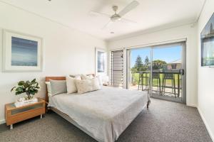 ein Schlafzimmer mit einem Bett und einem großen Fenster in der Unterkunft Pilotage 3 - Ocean and Lighthouse views in Yamba