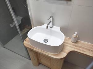 a bathroom with a white sink and a shower at Chata Wilka - całoroczny dom z bali na wyłączność z 3 sypialniami in Brzegi Dolne