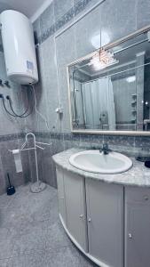 ein Bad mit einem Waschbecken und einem Spiegel in der Unterkunft Dream home in Amora