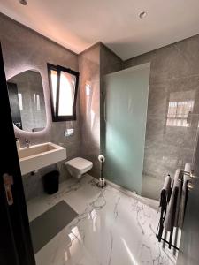 W łazience znajduje się umywalka, toaleta i lustro. w obiekcie Appartement Prestigia 3 chambres w Marakeszu