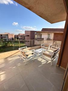 3 sedie e un tavolo su un patio di Appartement Prestigia 3 chambres a Marrakech