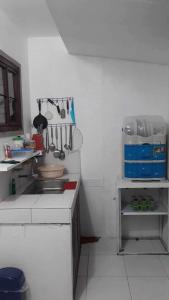 eine Küche mit einem Waschbecken und Küchenutensilien an der Wand in der Unterkunft Vin's Place Rentals (1-Bedroom unit) in Tagum