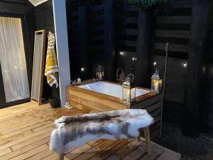 a bathroom with a tub with a faux fur bench and candles at The Lighthouse - Boathouse Bay in Auckland