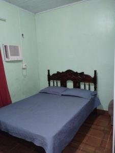 a bedroom with a bed with a blue comforter at Casa em Parintins in Parintins