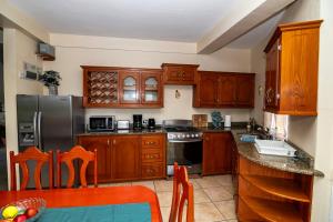 a kitchen with wooden cabinets and a table with chairs at Bocean Villa- Luxury Hilltop Retreat in Canaries