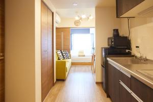 una cocina con fregadero y un sofá en una habitación en SG Premium KASAI - Vacation STAY 44266v en Tokio