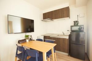 eine kleine Küche mit einem Tisch und einem Kühlschrank in der Unterkunft SG Premium KASAI - Vacation STAY 44353v in Tokio