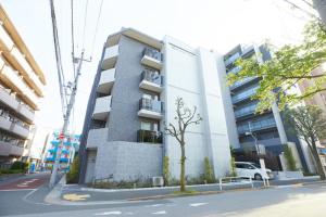 un edificio alto con un camión blanco estacionado frente a él en SG Premium KASAI - Vacation STAY 44353v en Tokio