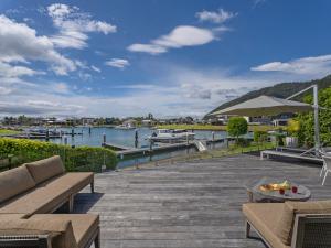 a dock with benches and a view of a marina at Villa Viti - Pauanui Holiday Home in Pauanui