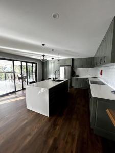 cocina grande con encimera blanca y suelo de madera en Tree Top View, en Brooks Bay