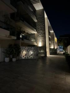 - un bâtiment éclairé la nuit avec une terrasse dans l'établissement Departamento Adrogue Cordero Plaza Wifi 60m2 piscina zona restaurants y bares, à Adrogué