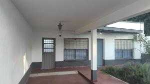 una casa bianca con una porta e un portico di casa con garaje rejas y camaras a 24 minutos del aeropuerto Ezeiza Amplio parque para mascotas a Ezeiza