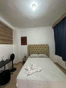 sypialnia z łóżkiem z ręcznikami w obiekcie Habitación acogedora w mieście Flores