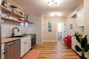 een keuken met houten vloeren en witte kasten bij Bridge City Row House in Pittsburgh