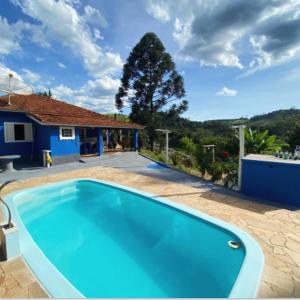 a swimming pool in front of a house at Estalagem Sitio Colibri in Cunha