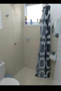 uma casa de banho com uma cortina de chuveiro e um WC em Nosso canto em Guaratinguetá