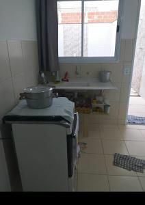 uma cozinha com um lavatório e uma panela no balcão em Nosso canto em Guaratinguetá
